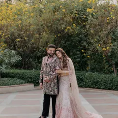 A beautiful outdoor portrait of a couple on their Roka day. The bride's stunning pink lehenga and the groom's intricate sherwani are captured in a natural, romantic setting.