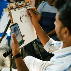 A live caricature artist at work, capturing the likeness of a visitor. Our workshops and live art sessions are a huge draw for all ages.