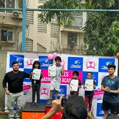 Capturing a moment of pride. Young champions from our badminton academy celebrate their victory with medals and certificates.
