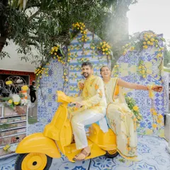 Capturing pure joy and sunshine at a Mediterranean-themed Haldi. This fun photo-op with a vintage yellow scooter was a highlight, perfectly matching the couple's vibrant personalities.
