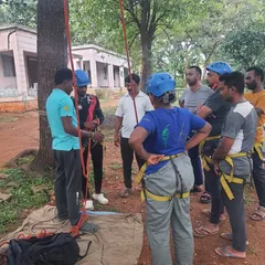 Safety is our first priority. An instructor provides detailed, hands-on guidance on how to properly wear and check a climbing harness before participants begin their ascent.