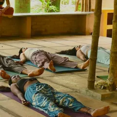 Finding stillness in Savasana. Our yoga pants, seen here in a shibori-style tie-dye and a solid earth tone, are made from soft, breathable fabrics that allow for complete relaxation and freedom of movement.