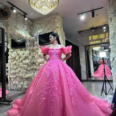 A client posing in the vibrant pink ball gown in my studio. The mirror reflects the dress, showing how it looks from all angles in our beautifully lit space.