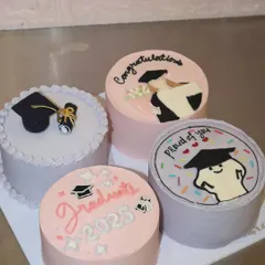 Celebrating a huge achievement with a sweet treat! This set of four graduation-themed bento cakes includes hand-piped illustrations, a fondant graduation cap, and congratulatory messages for the class of 2025.
