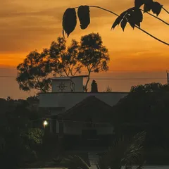 The silhouette of the ashram against a fiery sunset sky. Each evening here is a spectacle of color and a reminder of the beauty of the natural world.