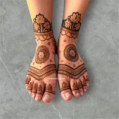 This elegant foot mehendi features a central lotus mandala and a matching lotus anklet. The design is symmetrical and balanced, with simple details on the toes.