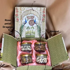 An inside look at one of my designer dry fruit boxes. This four-jar set includes almonds, cashews, rose petal dragees, and mixed granulars, all nestled in a beautiful peacock-themed box.