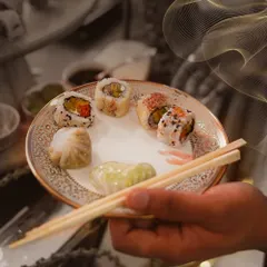 A plate showcasing our pan-Asian expertise, with a selection of delicate dim sum and sushi. This demonstrates the variety and artistry we bring to our global cuisine menus.