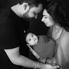 A timeless black and white portrait of new parents gazing at their baby. This intimate close-up captures the profound love and wonder of the newborn phase.