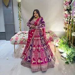 A real bride looking regal in a multi-toned pink and purple velvet lehenga. The rich fabric and detailed embroidery make this a showstopper for a winter wedding.