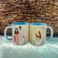 Here's another view of the personalized couple mugs, showing both the custom illustration on one side and the couple's initial logo design on the other. The light blue interior adds a nice touch of color.