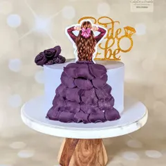 A simple and elegant cake for a bride-to-be. This design features a beautiful cascade of edible wafer paper petals to form a dress, topped with a custom topper.