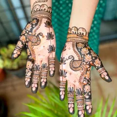A modern and artistic design with peacocks and lotuses on the palms. The open space gives it a light and contemporary feel. The groom's name, "Karan," is added on the wrist.