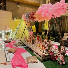 For this 17th birthday, I created a complete boho picnic experience. The setup includes low pallet tables, floor cushions, and a stunning overhead balloon installation in shades of pink.