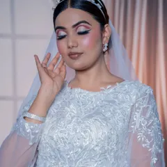 This shot with eyes closed highlights the delicate pink and white eyeshadow, perfect for a soft and romantic bridal style.