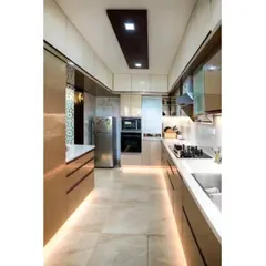 A luxurious parallel kitchen with glossy beige cabinets and integrated appliances. We used under-cabinet strip lighting along the base of the cabinets to create a floating effect and provide ambient light.
