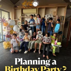 A group of kids and teens pose with letter balloons at a birthday party, showing how we can customize the studio space for your celebration.