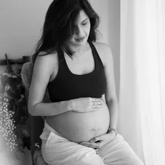 A moment of quiet connection with her baby. This simple, seated portrait in black and white is full of emotion and grace.