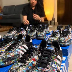 Here I am with a large commission of nine pairs of Adidas Sambas. Each shoe was hand-painted with a unique splatter design for a private client, showing how I can handle bulk orders for events or teams while ensuring every single piece is a work of art.