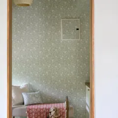 The foyer of 'House of Kismish' is named after the family's beloved pet, who welcomes everyone home. The space features subtle wallpaper and a bench, creating a warm and personal entrance.