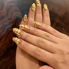 This is a full set of 3D textured gold chrome nails. The raised, liquid-like pattern gives the metallic finish incredible dimension and shine.