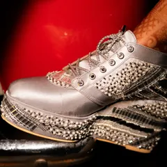 A unique detail shot of the bride's customized, embellished platform sneakers. This photo highlights her personal style and the fun details of her wedding look.
