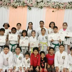 A full group photo from the belt and certificate distribution ceremony at Rejoice International School. It is an honor to see so many students, from young children to teenagers, proudly displaying the rewards of their hard work and discipline.
