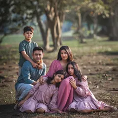 This portrait of a family of five, nestled together outdoors, has the feel of a classic painting. The composition draws you in, showcasing the close-knit bond and the different personalities within the family.
