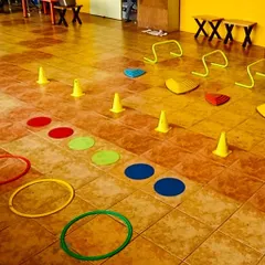 An indoor obstacle course ready for action. We use a combination of hoops for jumping, cones for weaving, and hurdles for leaping to create a full-body workout that feels like play.