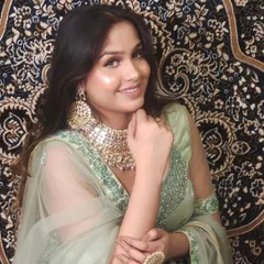 A smiling model in a pastel green outfit, wearing a beautiful Polki choker. A perfect look for a summer wedding or mehendi.