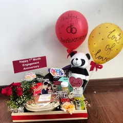 A sweet hamper to celebrate a one-month engagement anniversary. This compact tray includes a small bouquet of roses, a panda toy, a protein drink, and snacks, showing that every milestone matters.