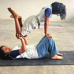 A playful and challenging pose, this "flying" position helps the child on top develop balance and confidence, while the base partner builds leg and core strength.