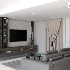 A contemporary family TV room featuring a full-wall entertainment unit with integrated shelving and storage. The dark grey tones and marble-effect back panel create a sophisticated and cinematic feel.