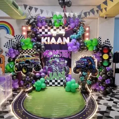 Another look at the incredible Monster Jam setup for Kiaan's birthday. The combination of black, purple, and green balloons with checkered flags and traffic light details made this theme a huge hit.