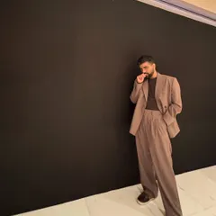 A candid moment from the same event. The all-black background really makes the silhouette of the suit stand out.