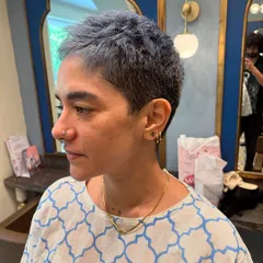 A bold haircut can be incredibly freeing. For this look, I went with a super short, textured ash-blue crop cut. It's an edgy, low-maintenance style that highlights her features perfectly.