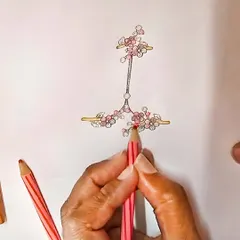 The journey of a jewel often starts with a splash of colour. Here, a design for a delicate floral hand harness is being brought to life with coloured pencils, mapping out the placement of each pink gemstone and diamond.