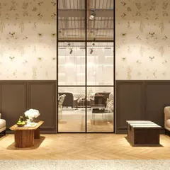 This rendering shows a formal waiting area or living room setup. The design uses classic furniture silhouettes, elegant wallpaper, and paneled walls to create a sophisticated and timeless atmosphere.