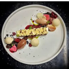 A deconstructed dessert plate. This artistic creation features different elements like chocolate mousse, ice cream, cake crumble, and fruit coulis, offering a variety of textures and flavors.