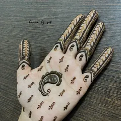 A minimalist design with a single paisley in the center of the palm, surrounded by tiny, scattered motifs. The fingers feature a simple leafy vine pattern.