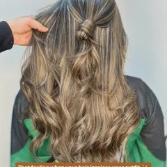 A perfect example of how a simple half knot can show off the beautiful dimension in a fresh balayage. The mix of light and dark tones creates a stunning effect.