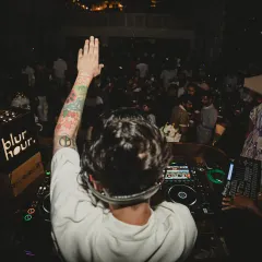 Greeting the crowd from the DJ booth at a "blur hour" event. I make sure to connect with the audience, whether it's a crowd of thousands or an intimate club.