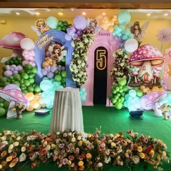 This enchanting Fairyland theme features magical mushroom houses, floral arrangements, and fairy cutouts. The setup includes a custom backdrop and a dedicated space for the cake cutting ceremony.