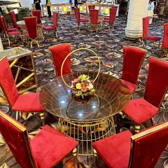 This round table seating arrangement uses high-back red velvet chairs. The gold wire-frame table and floral centerpiece match the other seating clusters for a cohesive look.