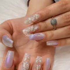 A different angle of the 3D floral and shimmer nail set, highlighting the craftsmanship of the sculpted flowers on the translucent extension base.