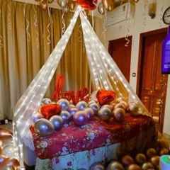 A cozy and romantic bedroom decoration. I used a canopy with fairy lights over the bed, which is filled with chrome balloons and a "LOVE" foil balloon.