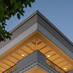 A detail shot of the KAIRA residence's corner, showcasing the intricate mouldings and the interplay of light and shadow on the facade. This demonstrates our commitment to precision in neo-classical design.
