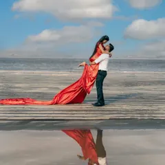 A stunning reflection shot of a couple on a wet sandy beach, with the groom lifting the bride. This is a perfect example of our creative beach pre-wedding photography.