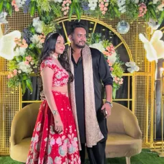 Another shot of the couple at their Sangeet, showing the beautiful floral arrangements and the warm glow of the decorative lights.