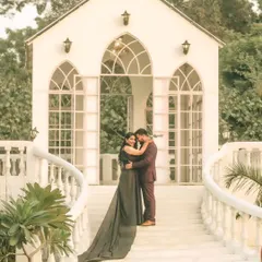 A fairytale moment from a pre-wedding shoot, featuring the couple in front of a beautiful white chapel-like structure. The bride's flowing gown adds a touch of elegance to this romantic portrait.